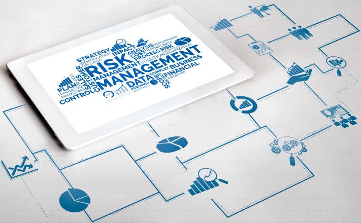 Tablet displaying a risk management word cloud connected to a GRC workflow diagram with analytics icons